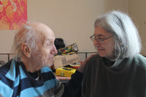 older white haired man on left and grey haired woman with glasses on right
