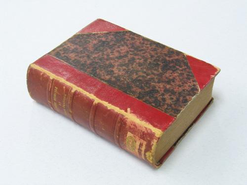 The bound book has a red cover and is well worn.