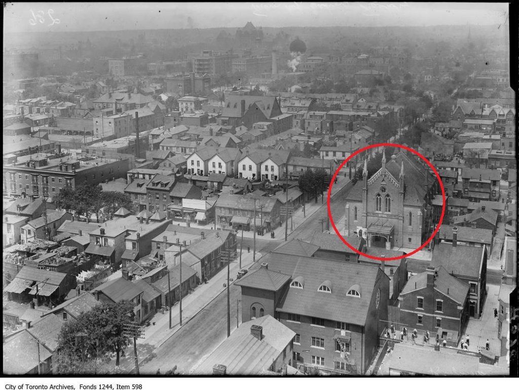 Looking north from the top of T. Eaton factory there is a cityscape showing many different kinds of residential, recreational, and industrial buildings. On the right side you can see the Lyric Yiddish Theatre circled in red.